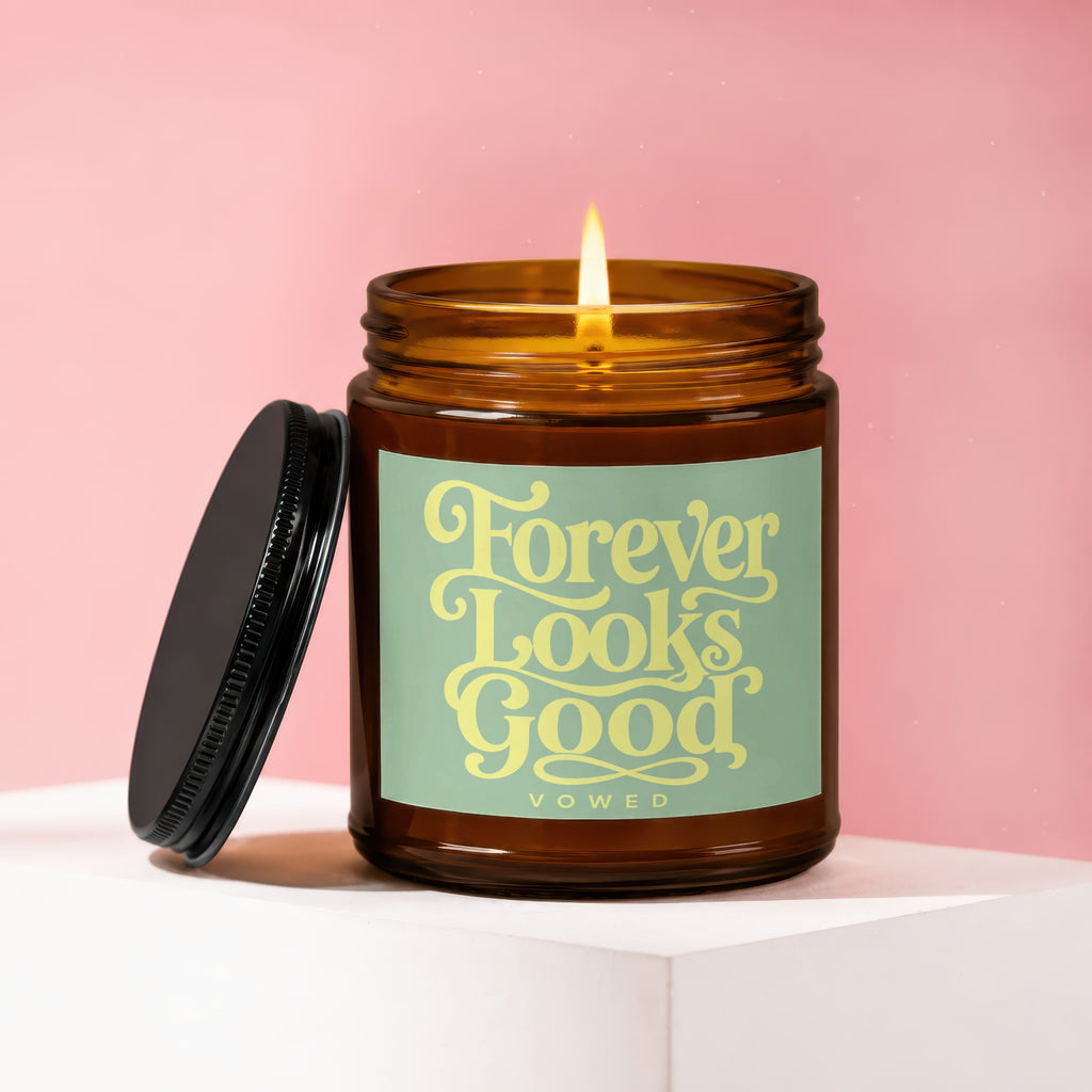 Amber candle with lit wick and label that reads "Forever Looks Good".