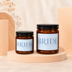 Two amber glass candles with black lids labeled "BRIDE".