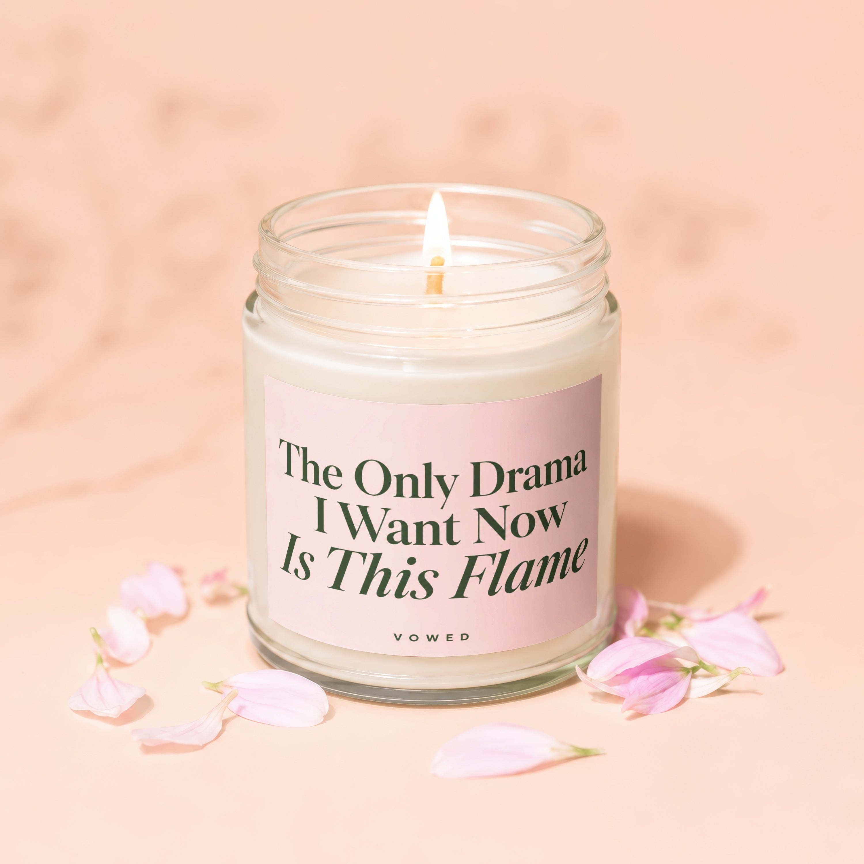 Scented candle in glass jar with pink label reading "The Only Drama I Want Now Is This Flame."