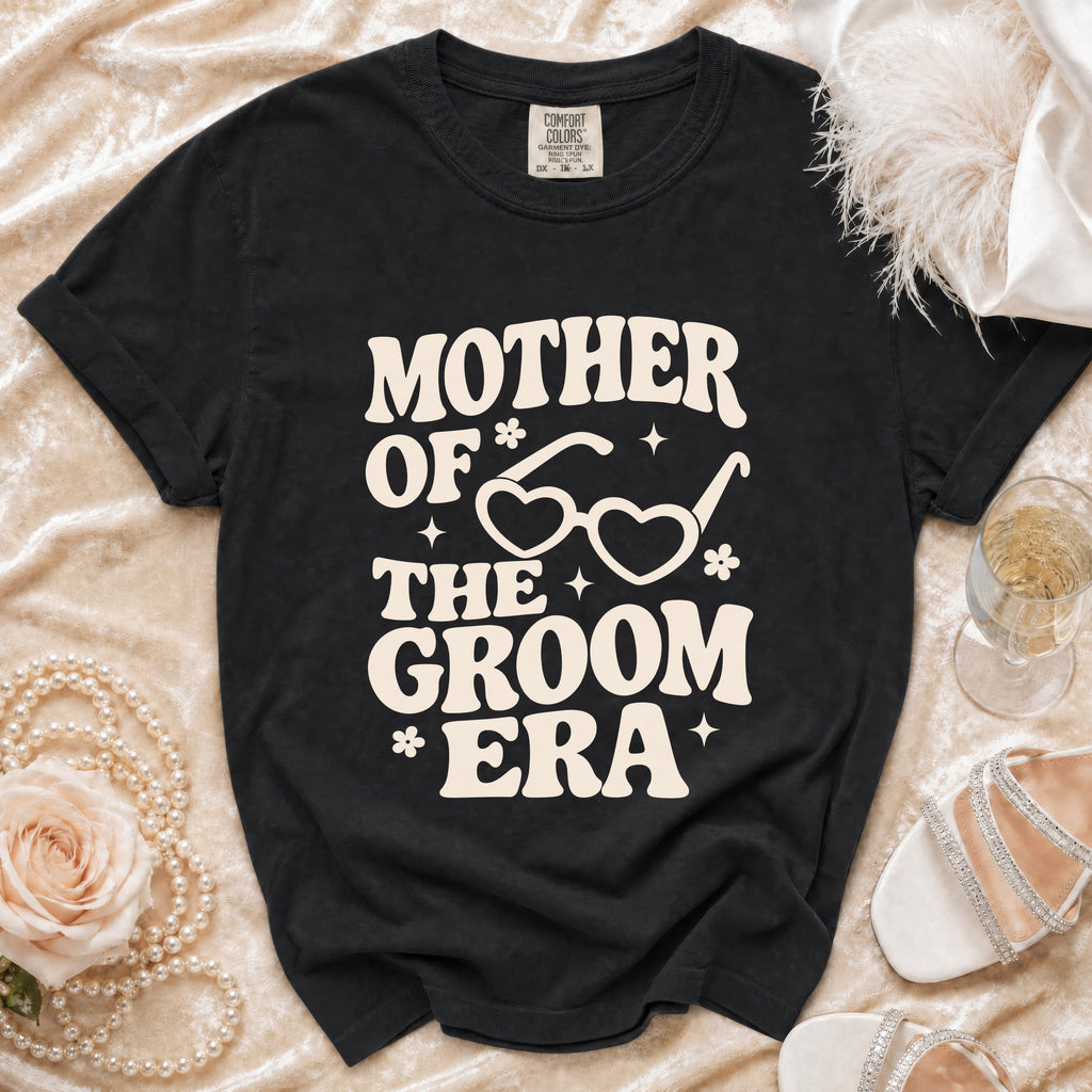 Black t-shirt with "Mother of the Groom Era" text and heart-shaped glasses graphic.