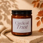 Amber glass candle with white label reading "Circle of Trust VOWED".