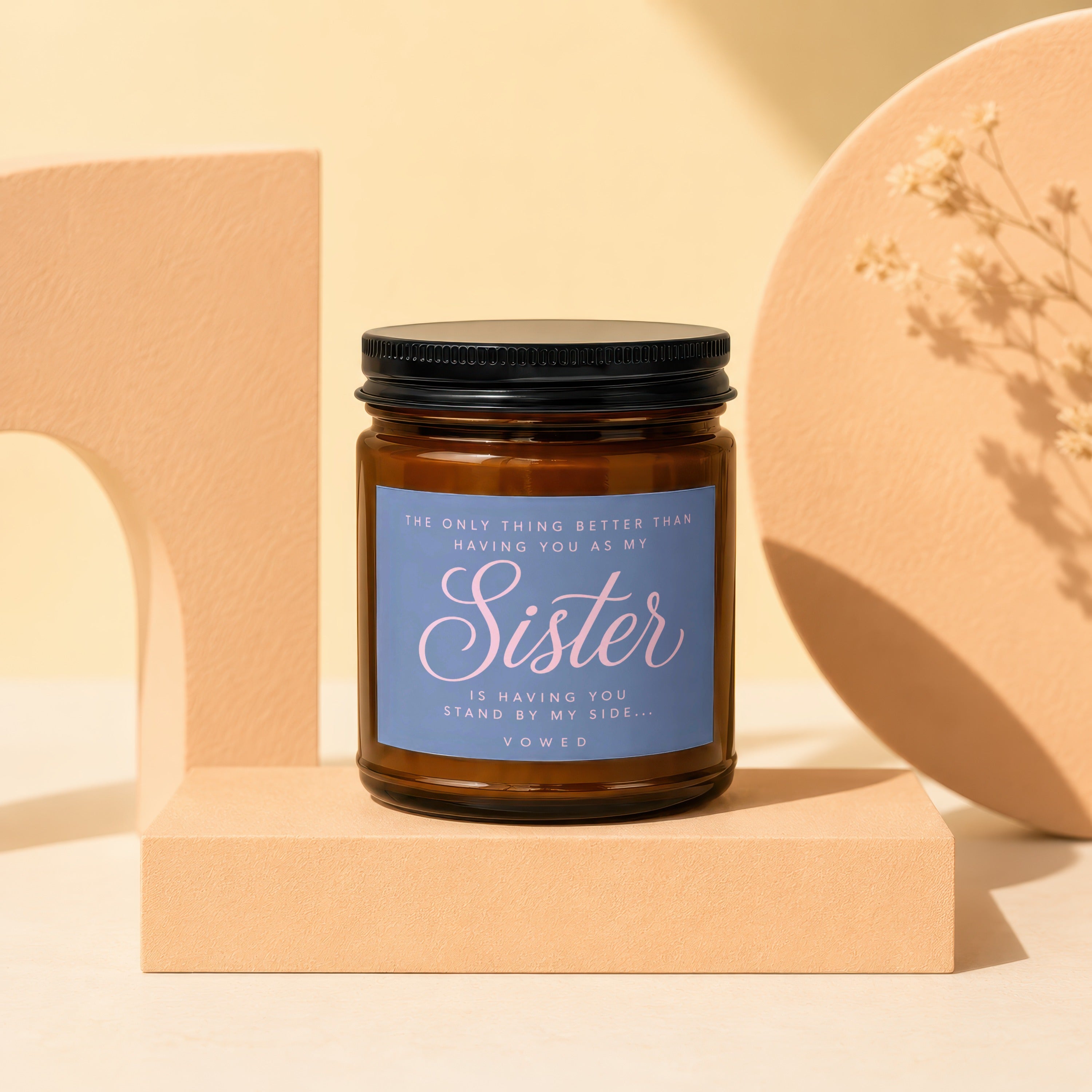 Brown candle with blue label that reads "Sister" and "Vowed".