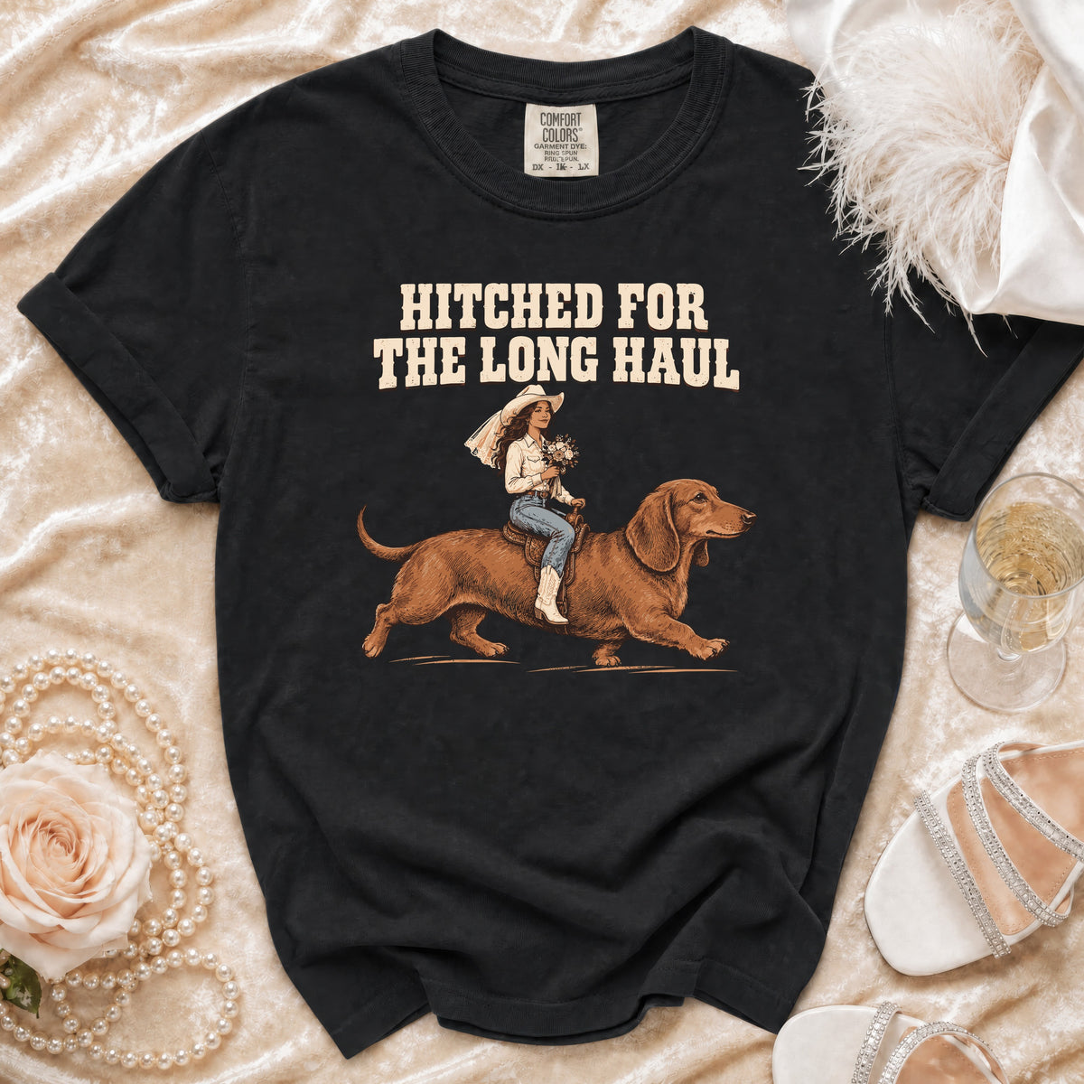 Black t-shirt with text "Hitched for the Long Haul" and illustration of bride riding a dachshund.