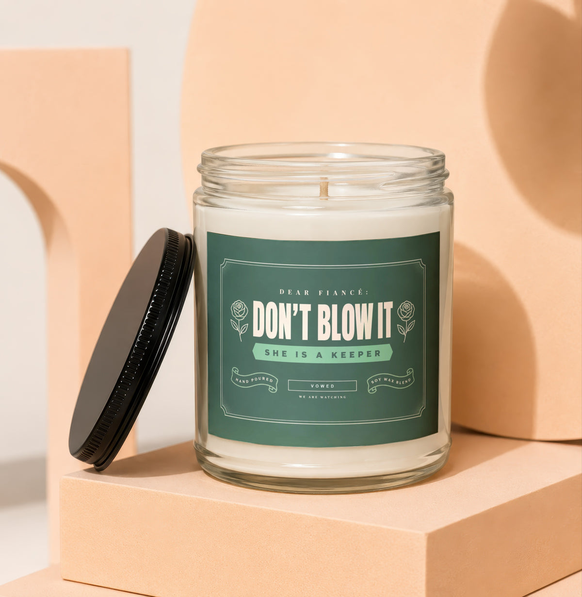 Glass jar candle with green label reading "Dear Fiancé: Don't Blow It, She is a Keeper."