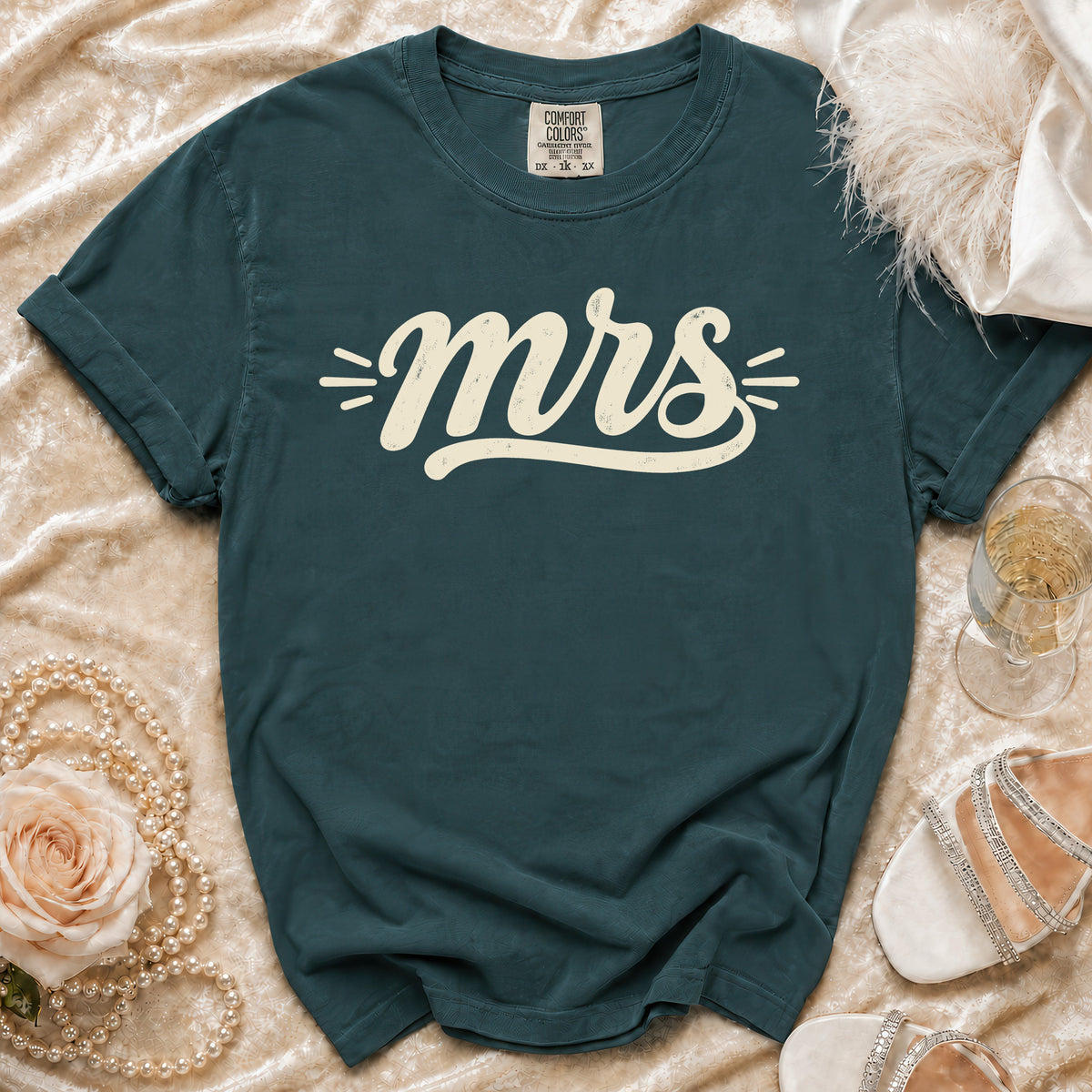 Teal t-shirt with "mrs" graphic, Comfort Colors tag, pearls, rose, and shoes.