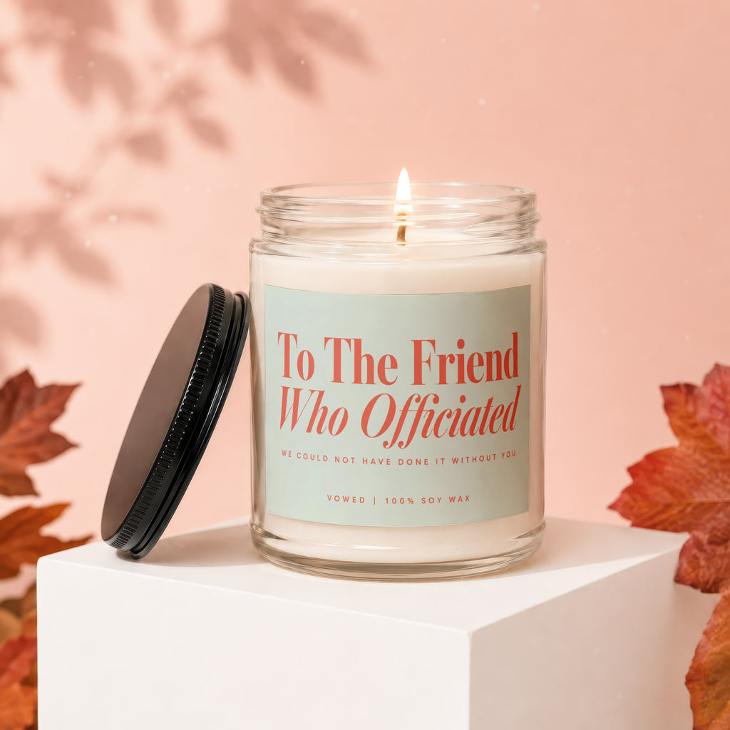 Glass candle labeled "To The Friend Who Officiated" with a lit wick.