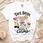 White t-shirt with "This Bride Needs a Cosmo" text and martini illustration.