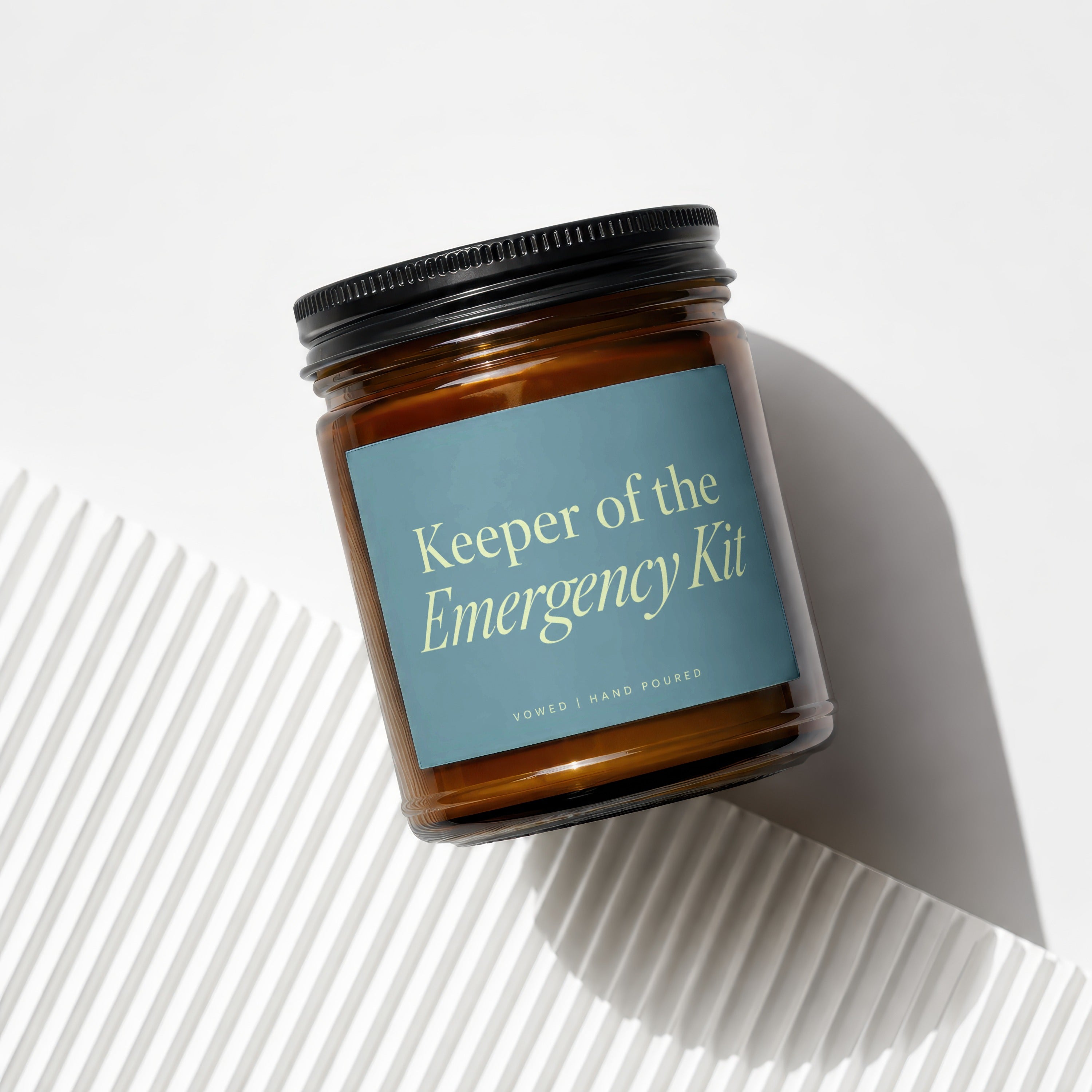 Amber jar candle titled "Keeper of the Emergency Kit," hand poured.
