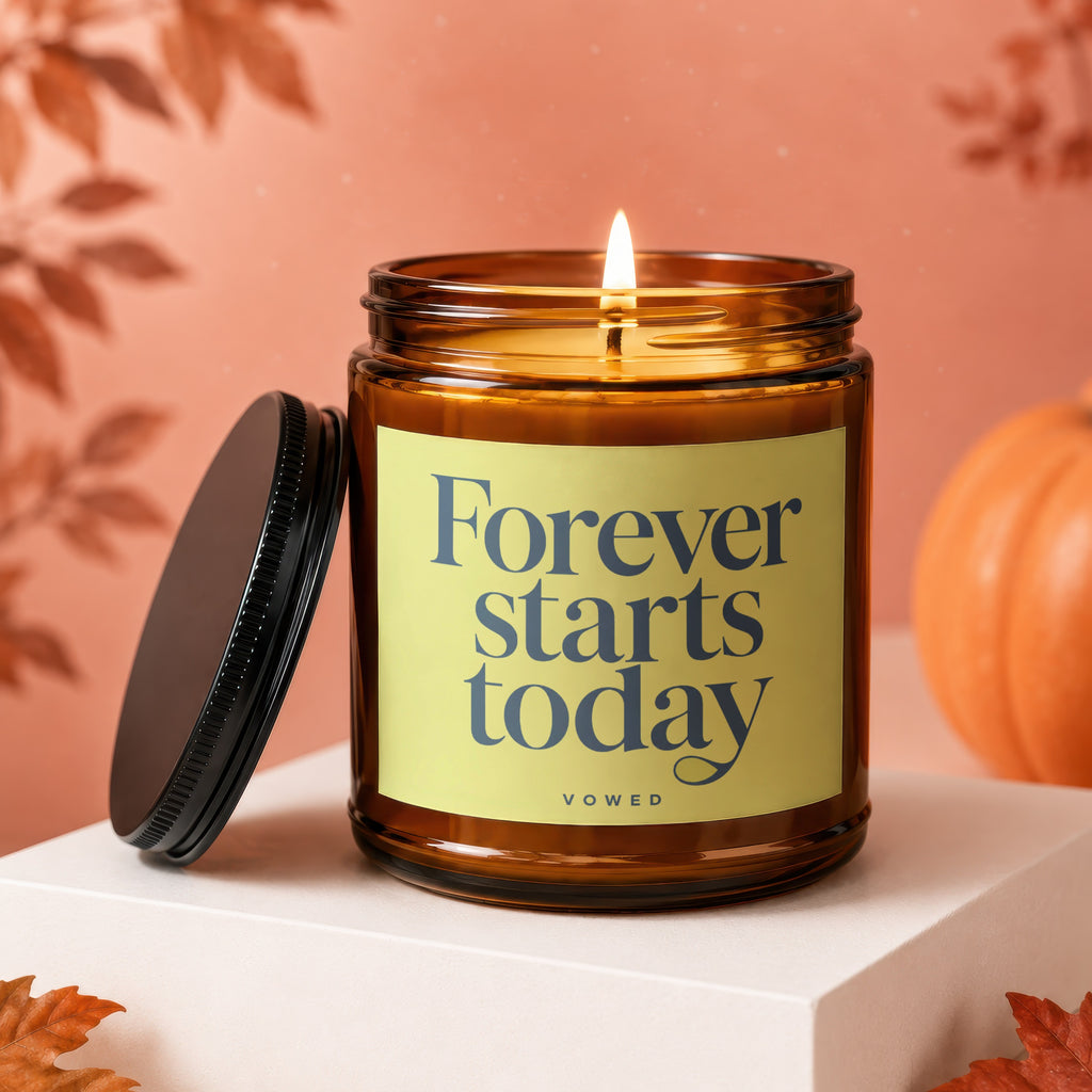 Amber jar candle with lit flame and text "Forever starts today".