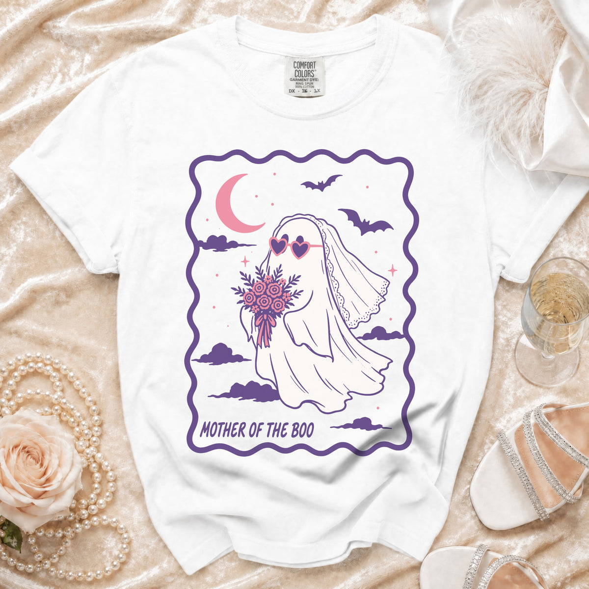 White t-shirt with graphic of a ghost bride holding flowers, text "MOTHER OF THE BOO".