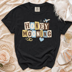 Black t-shirt with "HONEYMOONING" text, wedding rings, and airplane graphic.
