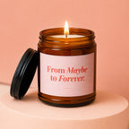 Amber candle in a jar with lid off, reading "From Maybe to Forever."