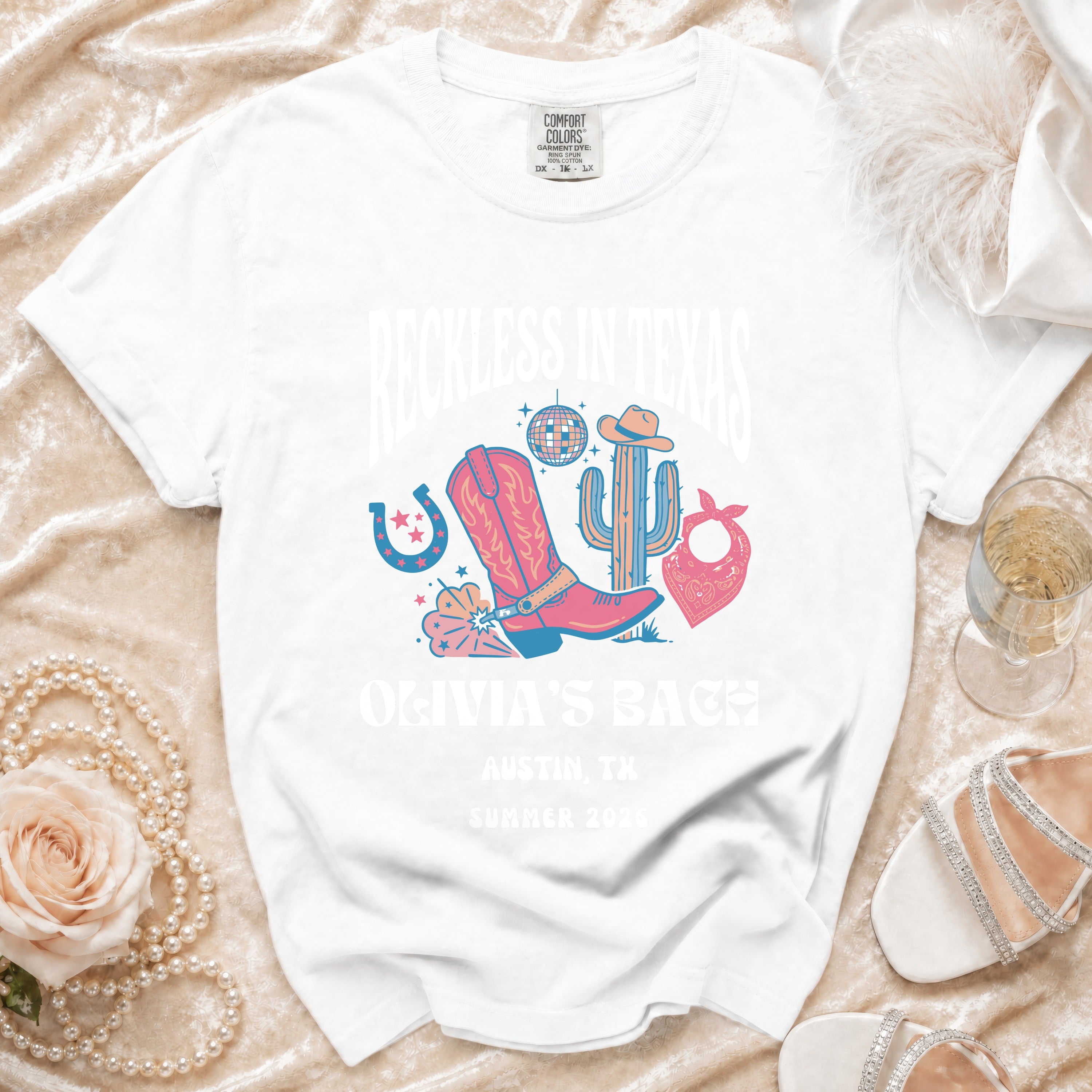White t-shirt with "Reckless in Texas" and "Olivia's Bach" for Austin, TX Summer 2026.