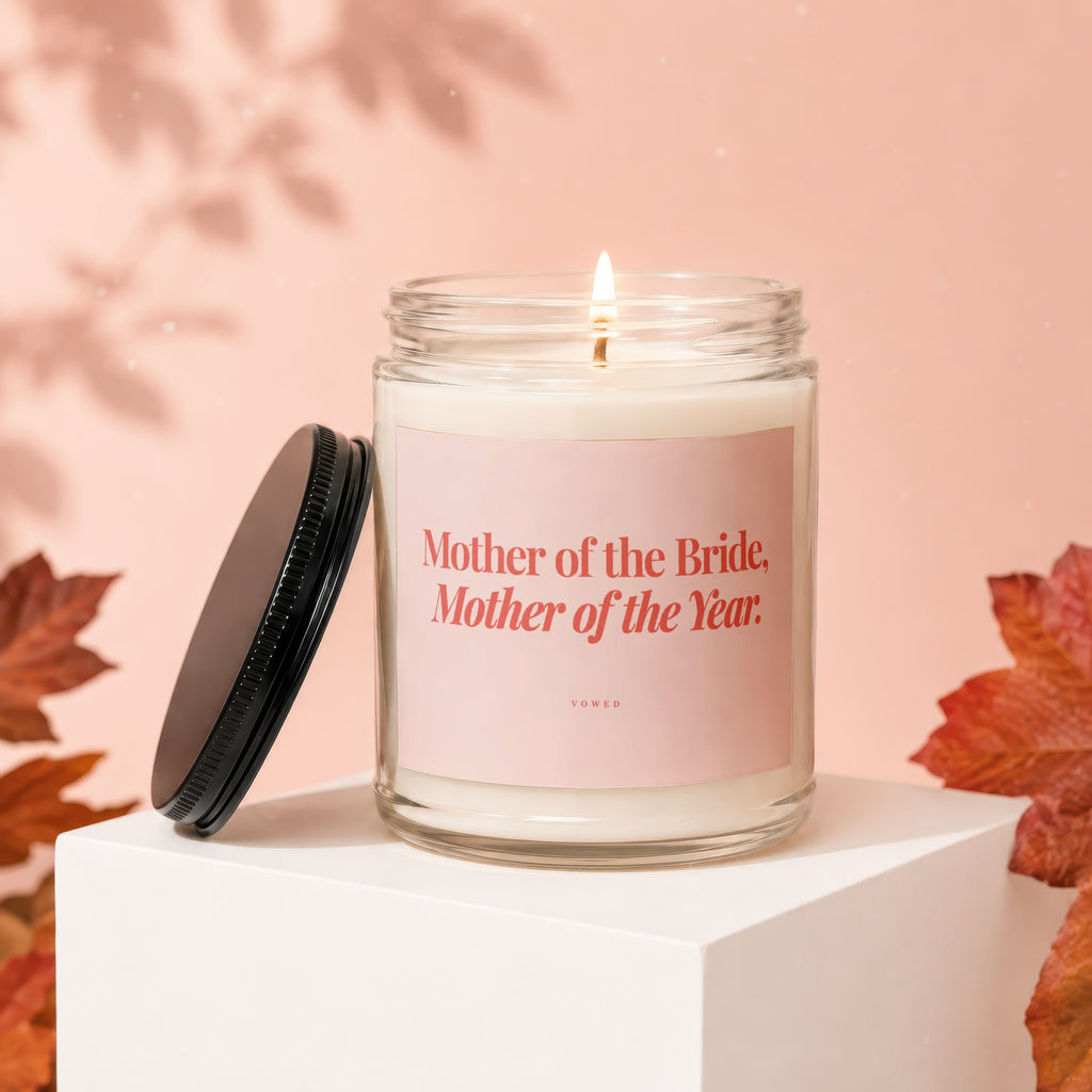 Glass jar candle with pink label reading "Mother of the Bride, Mother of the Year".