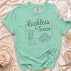 Green t-shirt with "Reckless in Texas" design for Olivia's Bach.