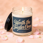 Lit candle in glass jar with dark lid, "Worth the Toaster Oven" text.