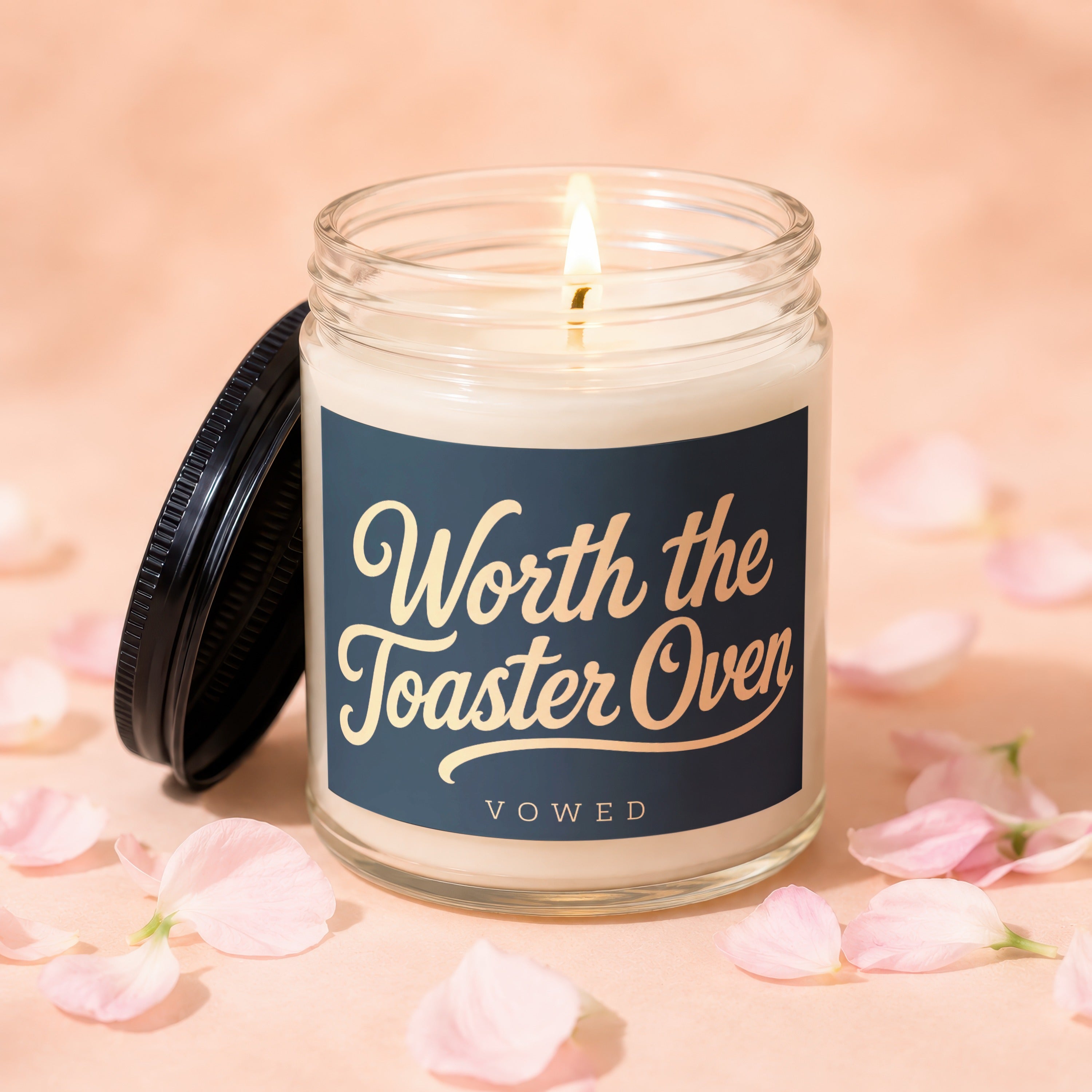 Lit candle in glass jar with dark lid, "Worth the Toaster Oven" text.