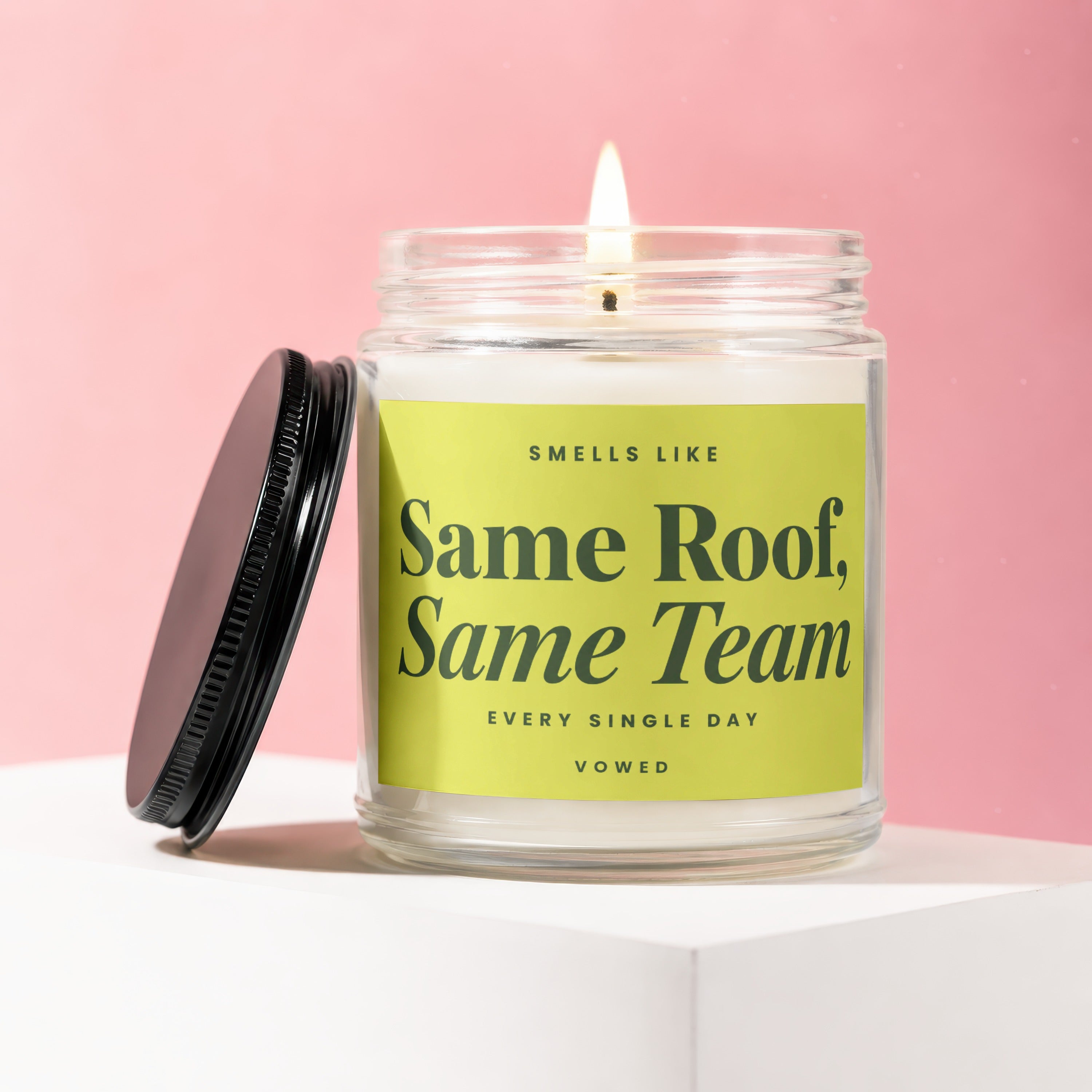 Scented candle with text "Same Roof, Same Team" on a lime green label.