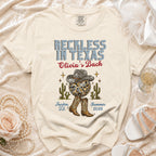 Cream t-shirt with "Reckless in Texas Olivia's Bach" text, disco ball, cacti, boots.