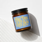 Amber jar candle with "Big Day, Gay Joy" text on a blue label.