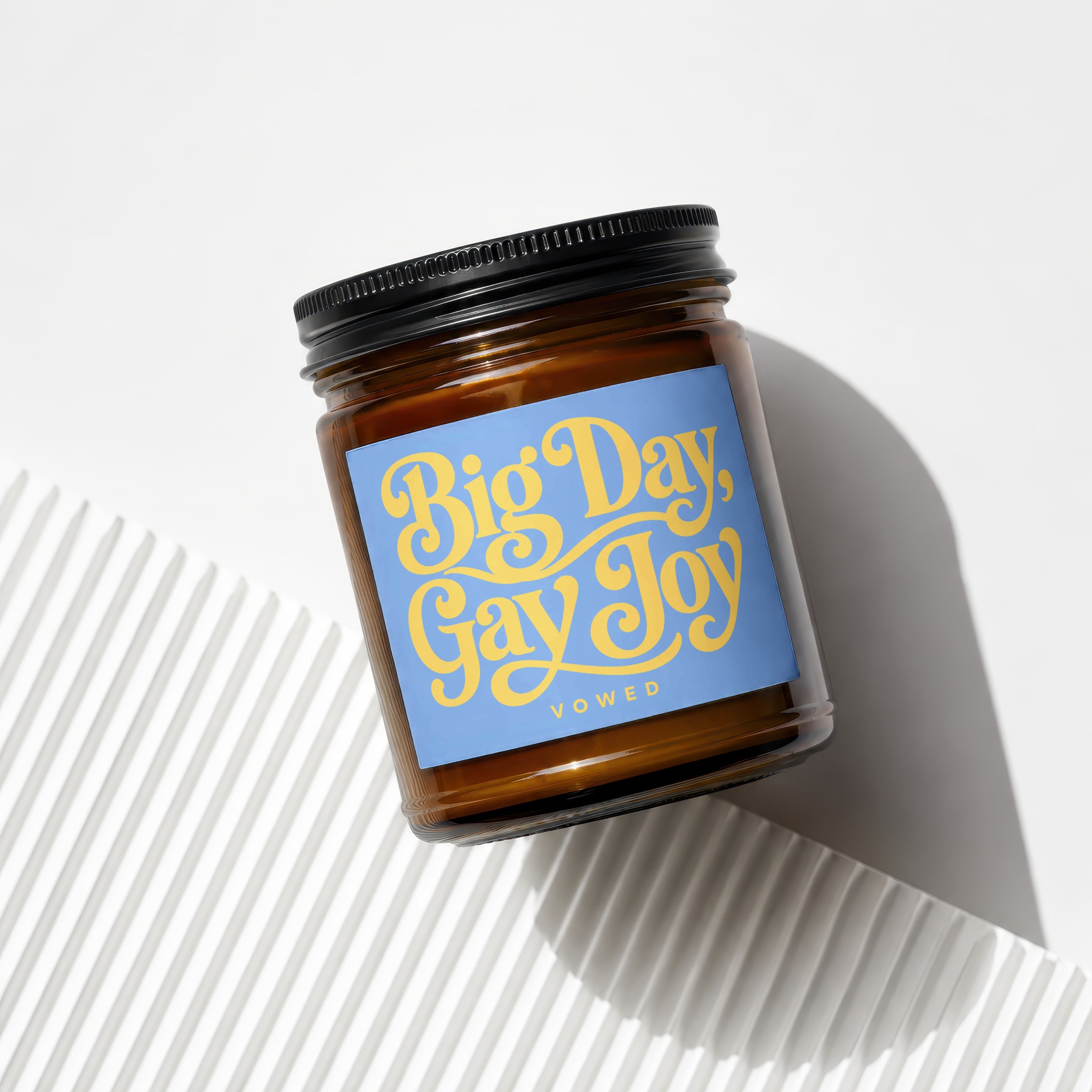 Amber jar candle with "Big Day, Gay Joy" text on a blue label.
