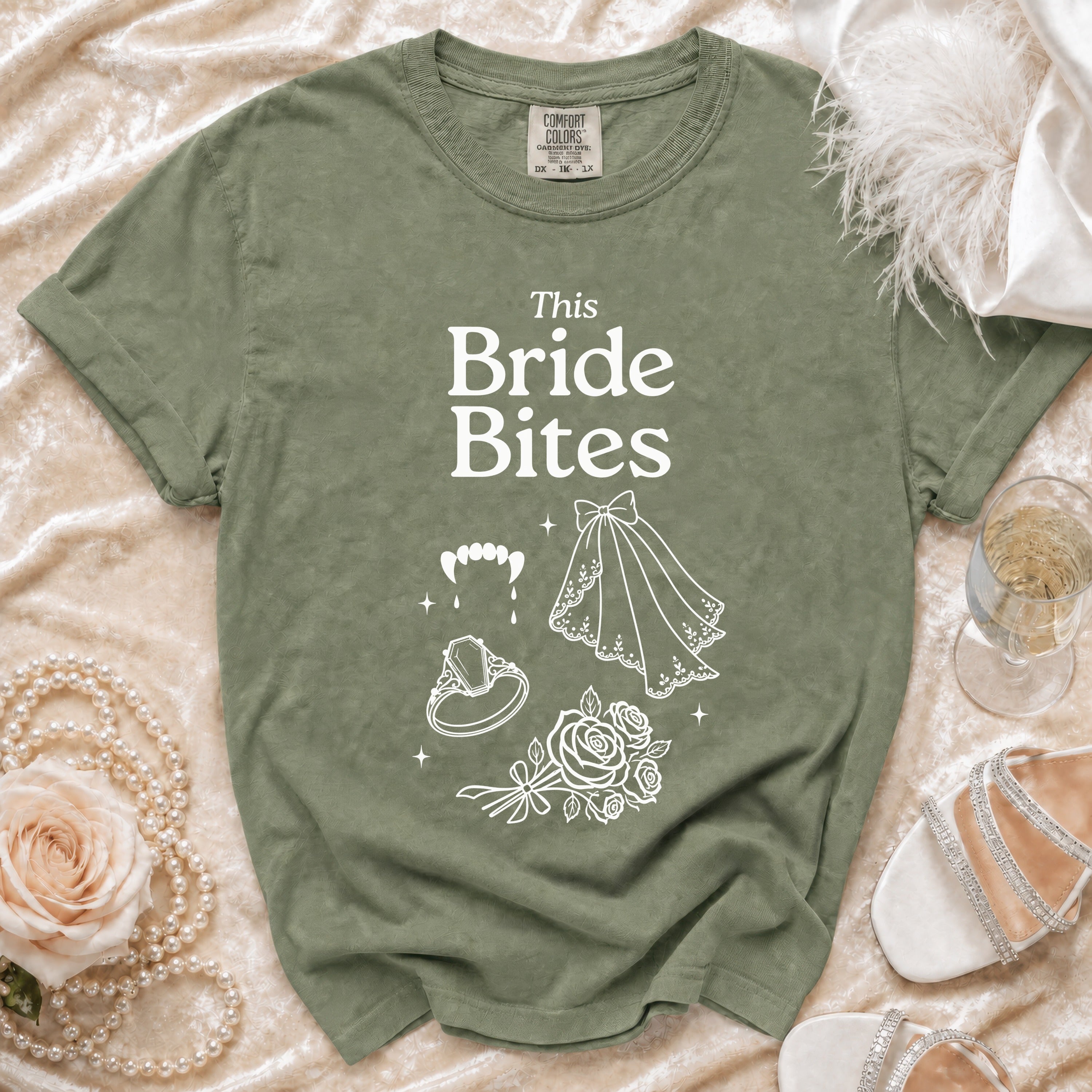 Olive green t-shirt with white "This Bride Bites" text and gothic wedding graphics.