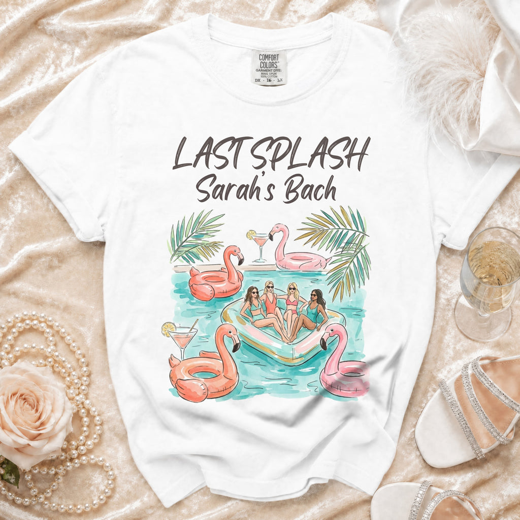 White t-shirt with "Last Splash Sarah's Bach" graphic of women on flamingo floats.