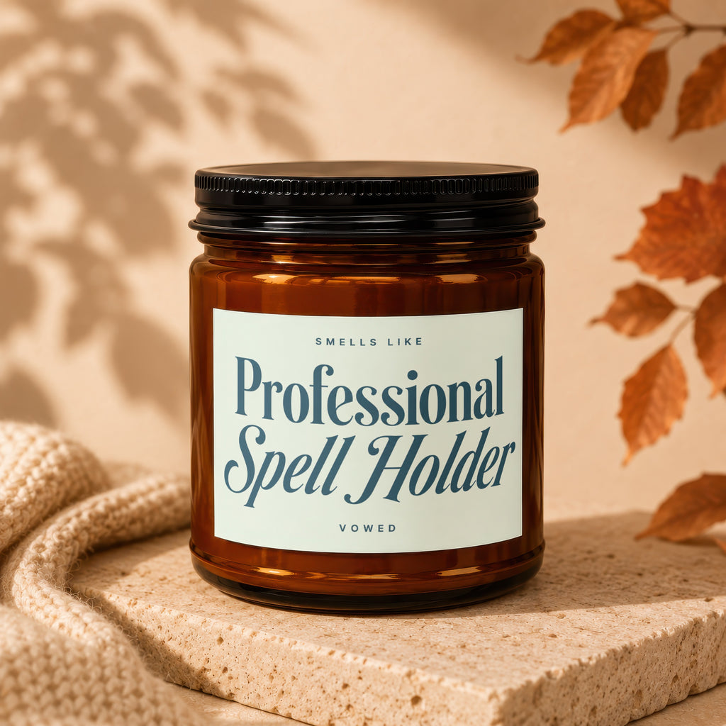 Amber jar candle labeled "Professional Spell Holder" with a beige background and fall leaves.