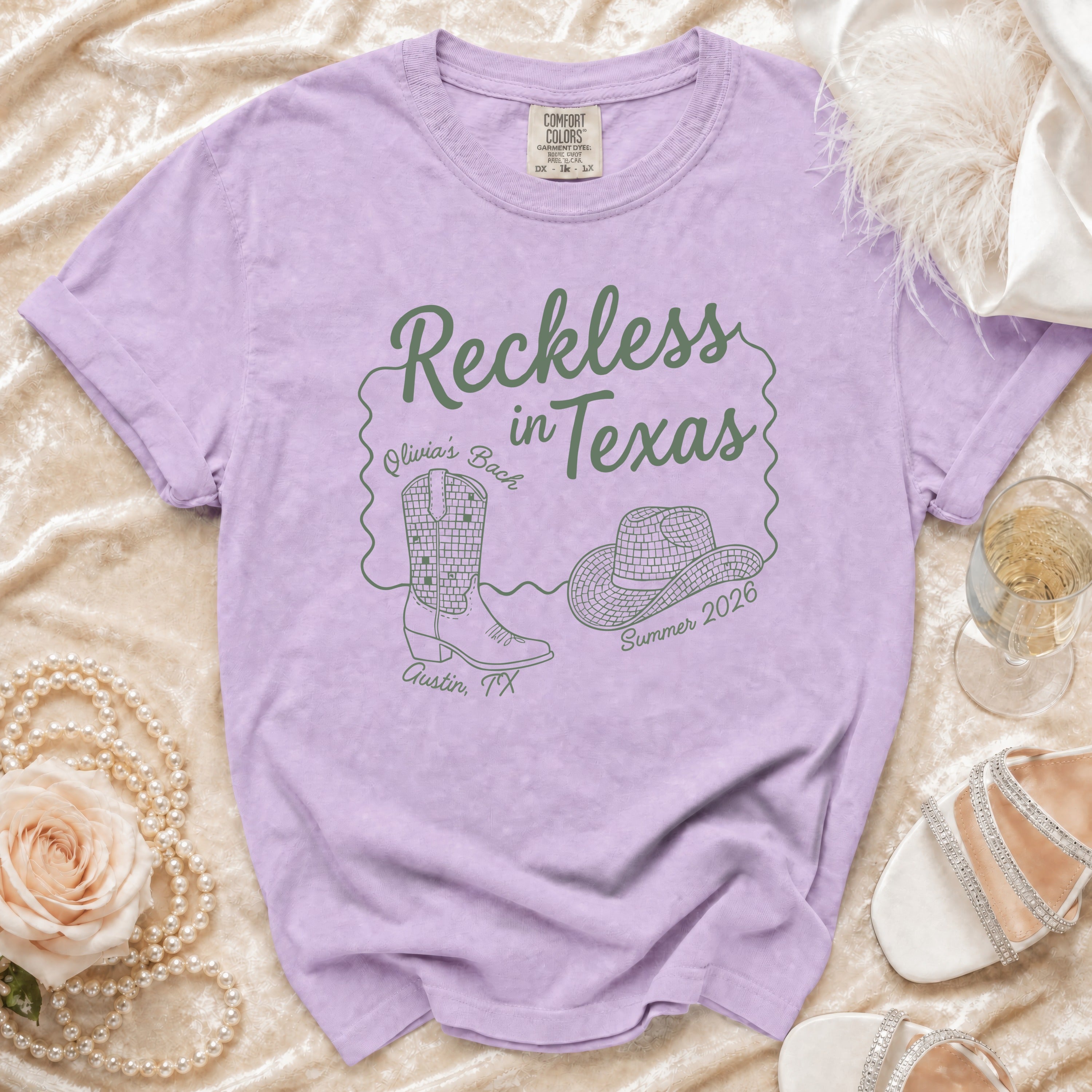 Purple t-shirt with "Reckless in Texas" text, cowboy boot, hat, and Austin TX details.
