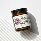 Amber jar candle with light green label reading "MOH Medal of Dishonor".