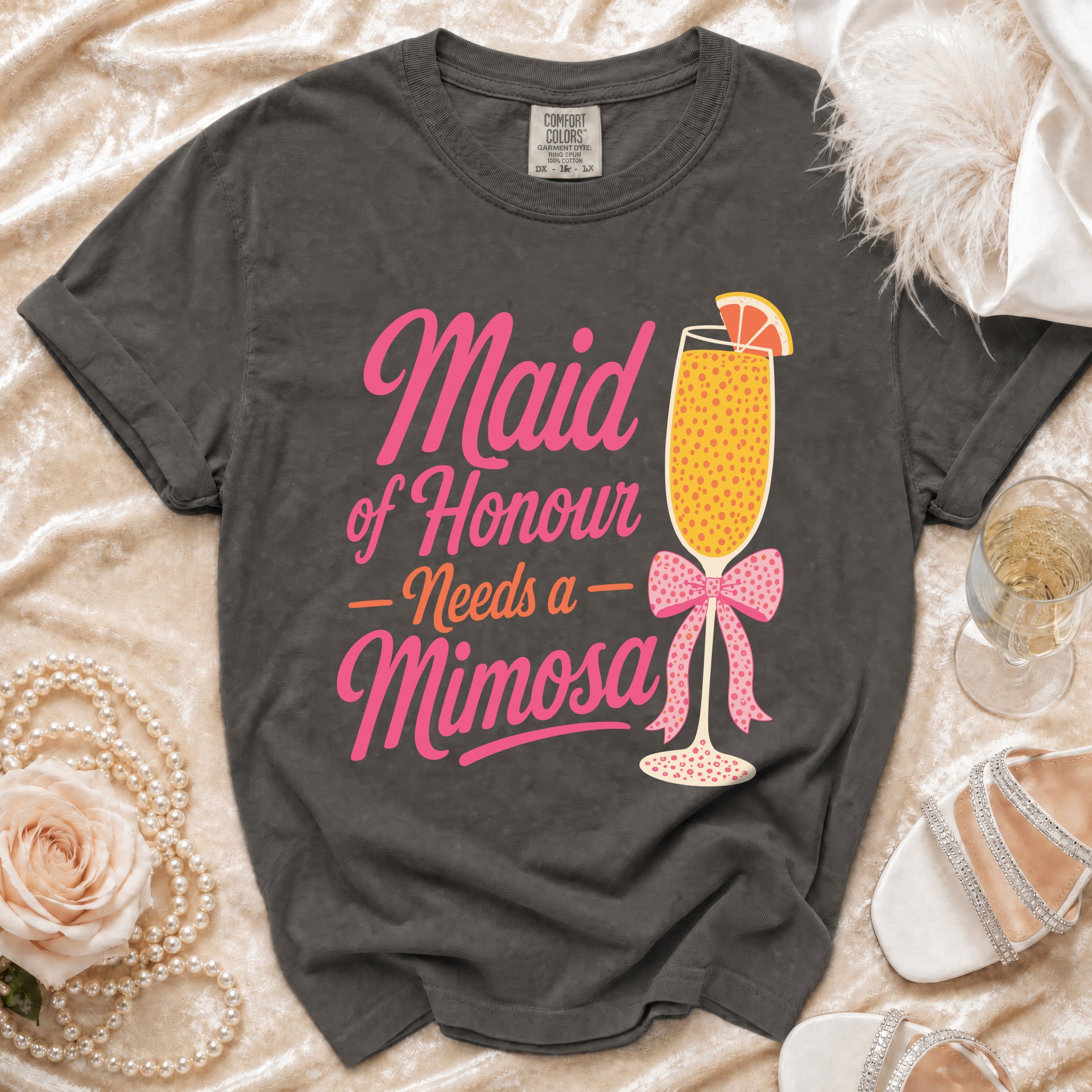 Grey t-shirt with pink text reading "Maid of Honour Needs a Mimosa" and graphic.