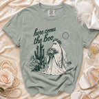 Ghost bride with bouquet in desert landscape on a sage green t-shirt.