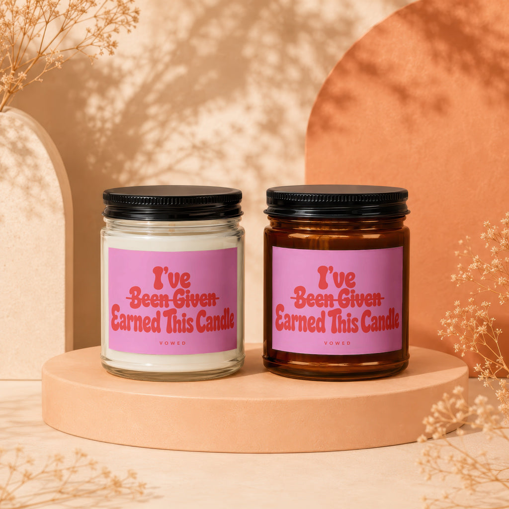 Two candles with pink labels that read "I've Been Given Earned This Candle."