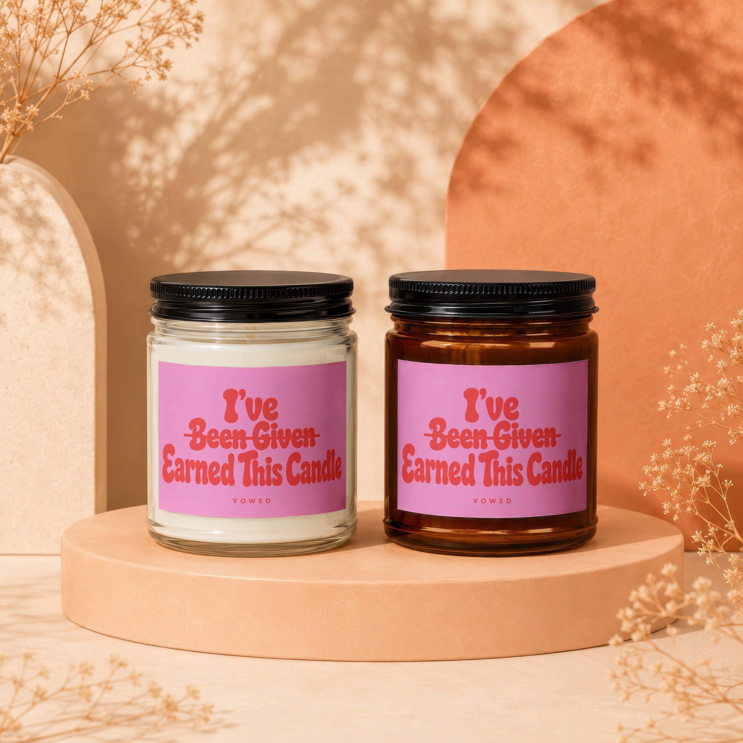 Two candles with pink labels that read "I've Been Given Earned This Candle."