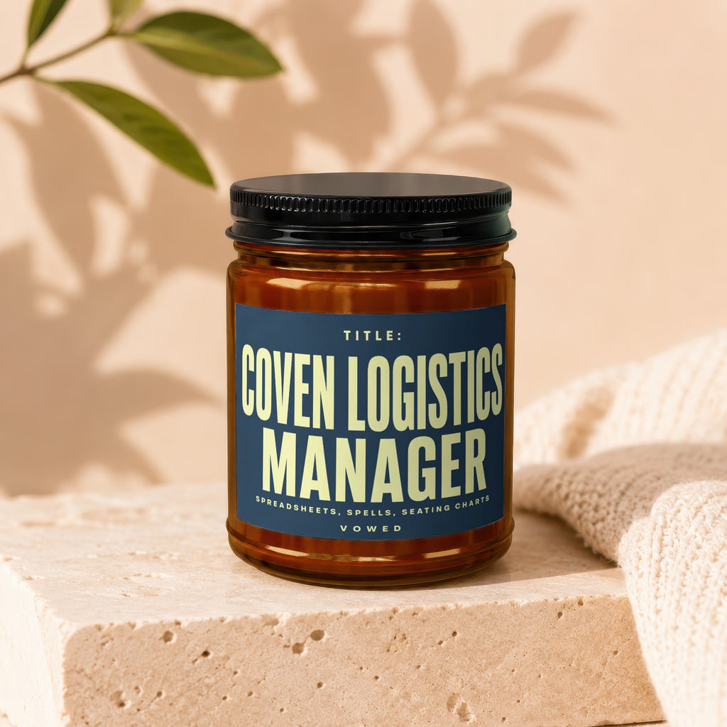 Amber jar with dark lid, label reads "Title: Coven Logistics Manager. Spreadsheets, Spells, Seating Charts. Vowed."