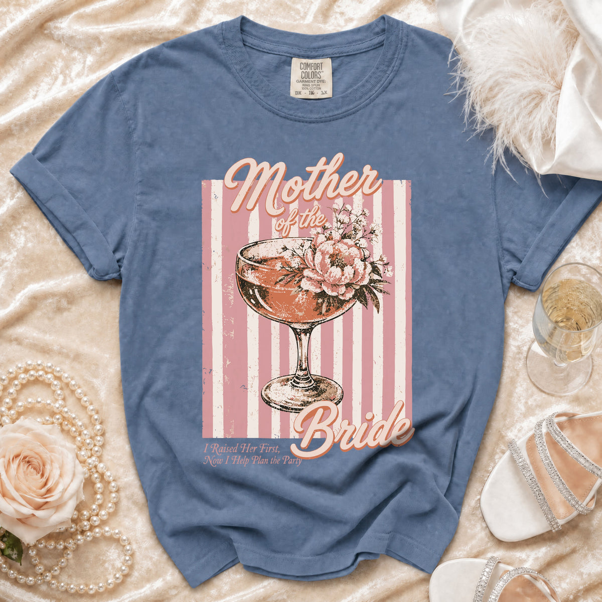 Blue t-shirt with "Mother of the Bride" design featuring a drink and flowers.