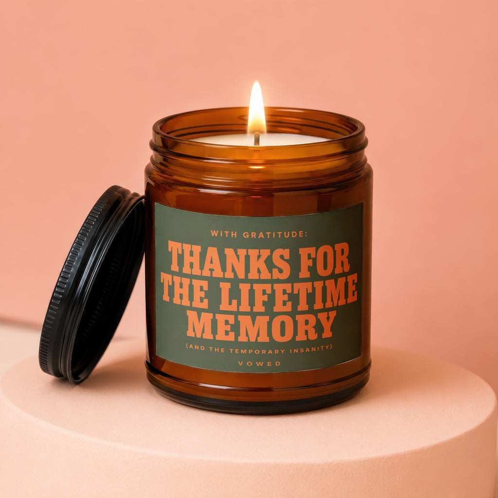 Amber candle with lid off, burning flame, reads "Thanks for the lifetime memory".