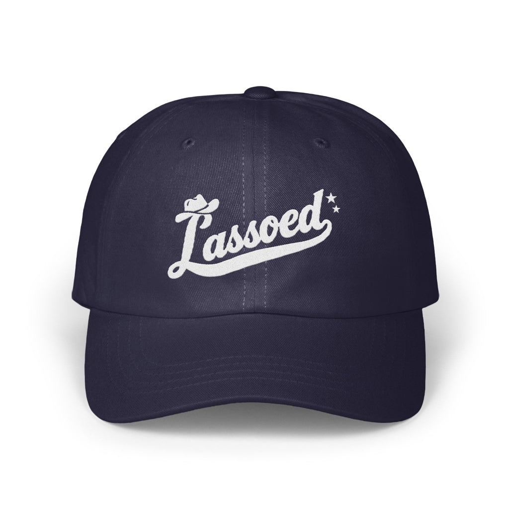 A dark blue baseball cap with white embroidered text reading Lassoed centered on the front panels.