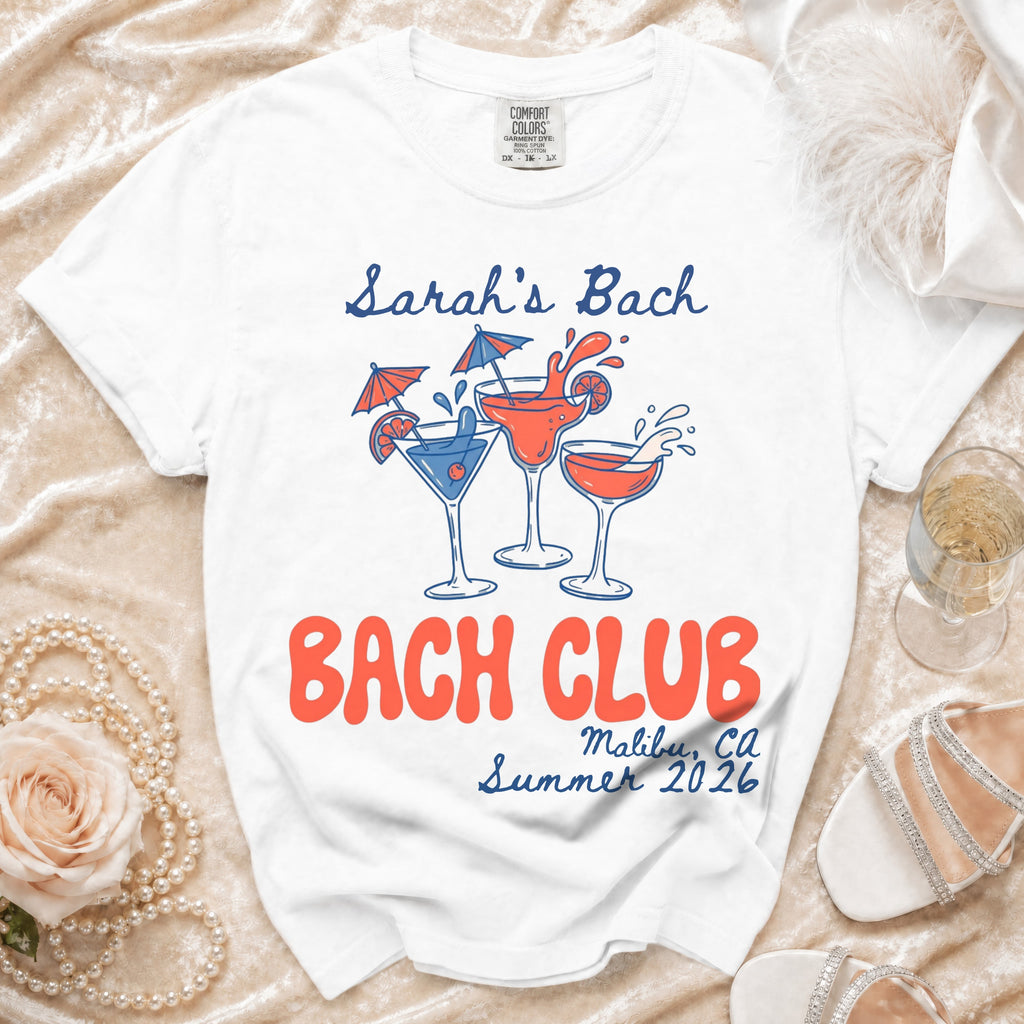 White t-shirt with "Sarah's Bach Bach Club Malibu, CA Summer 2026" text and cocktail graphics.