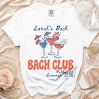 White t-shirt with "Sarah's Bach Bach Club Malibu, CA Summer 2026" text and cocktail graphics.