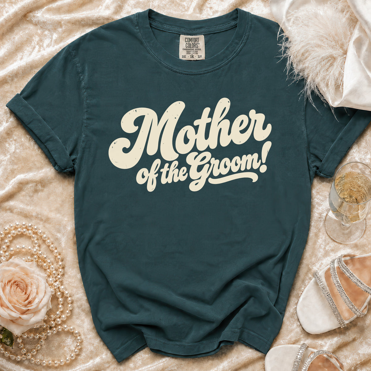 Teal t-shirt with "Mother of the Groom!" in cream retro text.