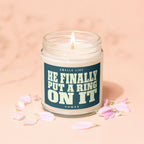 Scented candle in glass jar with label reading "Smells like he finally put a ring on it".