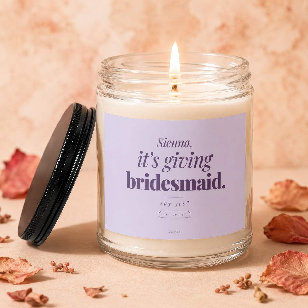 Lit candle with "Sienna, it's giving bridesmaid. say yes?" text and date on label.
