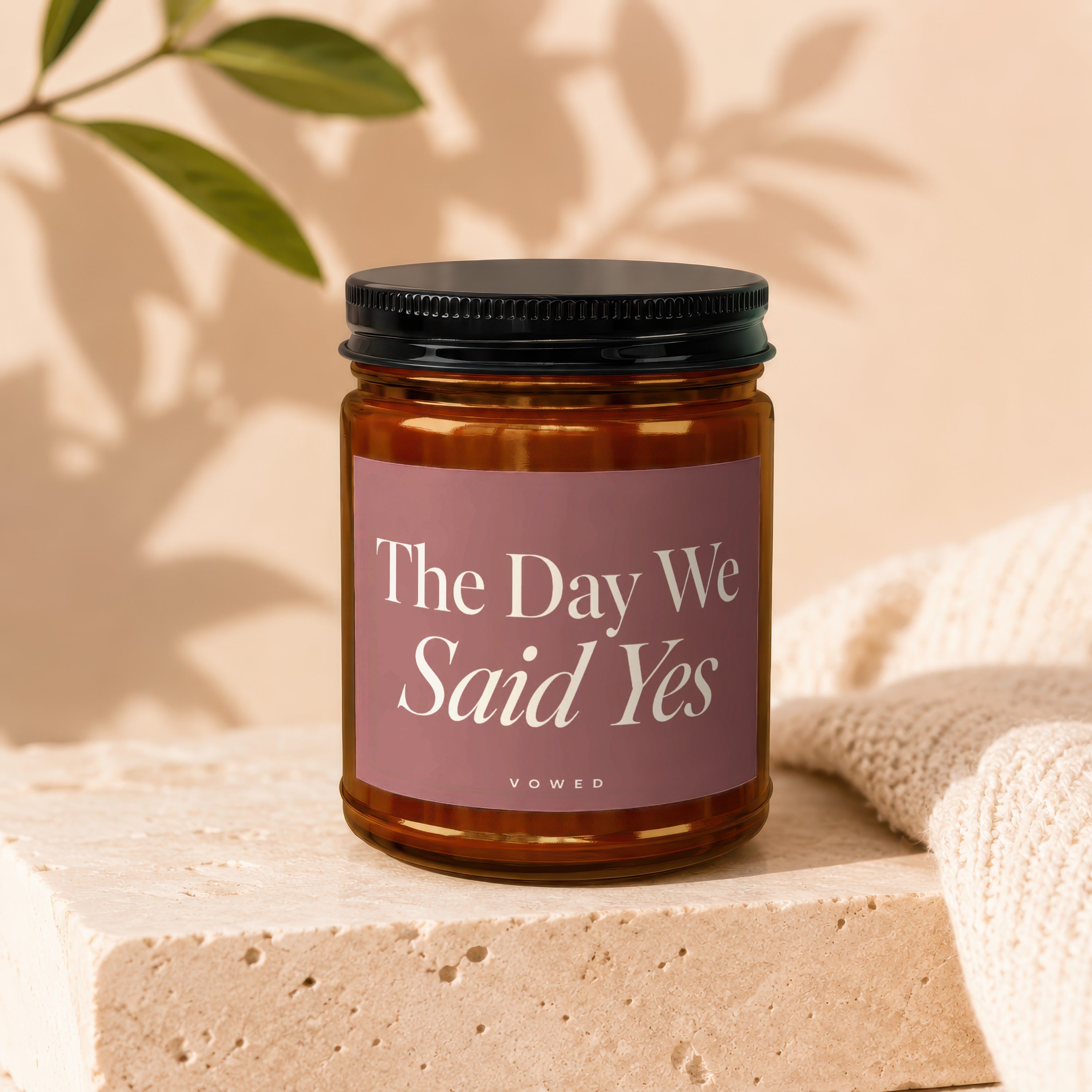 Amber jar candle with "The Day We Said Yes" text on a mauve label.