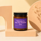 Amber glass candle with purple label reading "Welcome to Your Pre-Wedding Era."