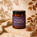 Amber candle with purple label reading "Two Moms. One Lucky Me."