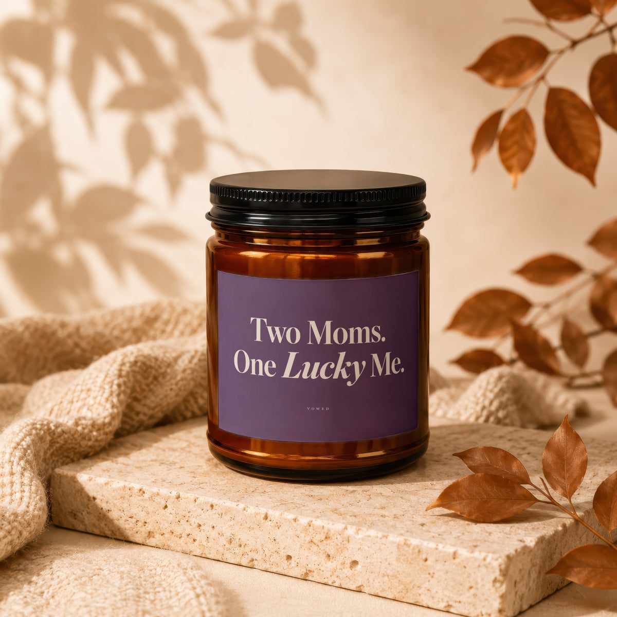 Amber candle with purple label reading "Two Moms. One Lucky Me."