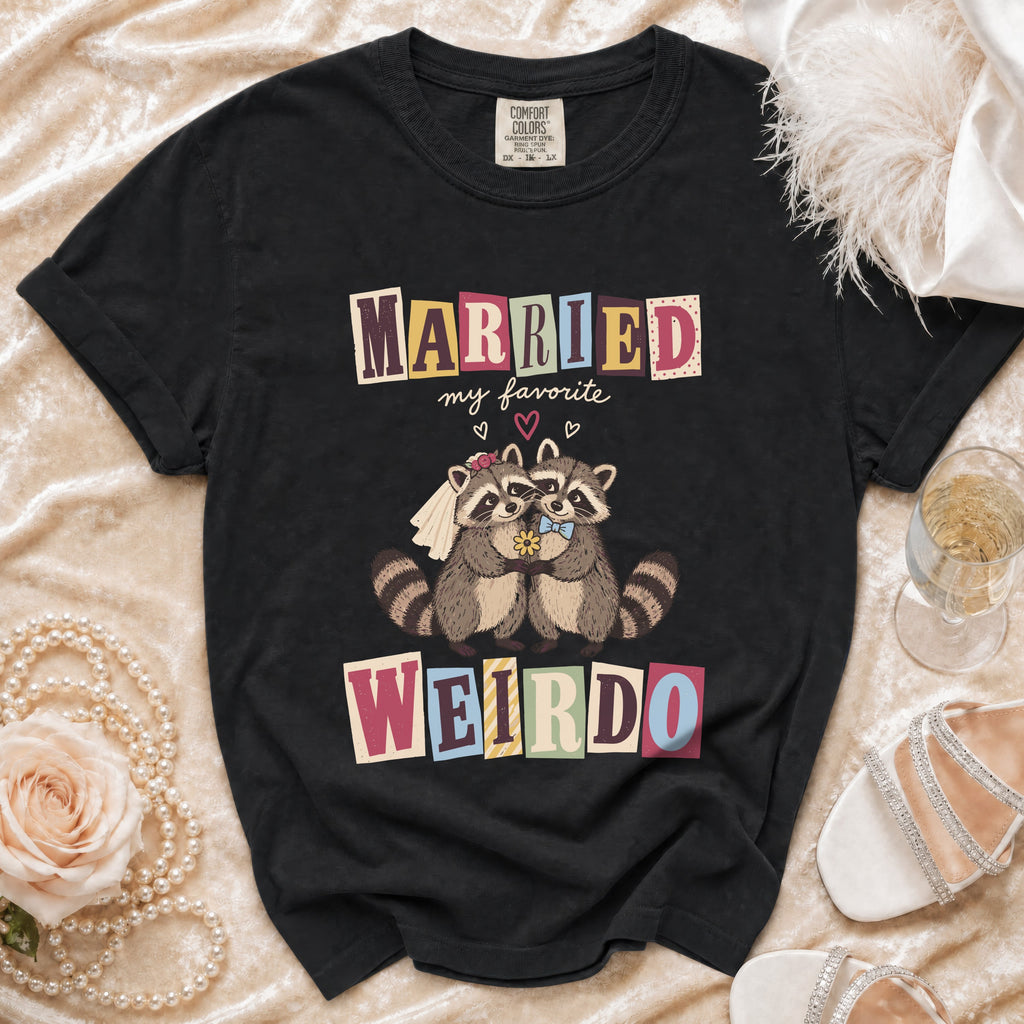 Black t-shirt with cartoon raccoons wearing wedding attire and text "MARRIED my favorite WEIRDO".