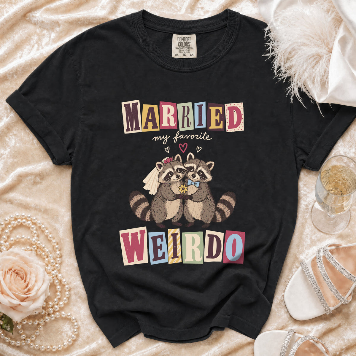 Black t-shirt with cartoon raccoons wearing wedding attire and text "MARRIED my favorite WEIRDO".