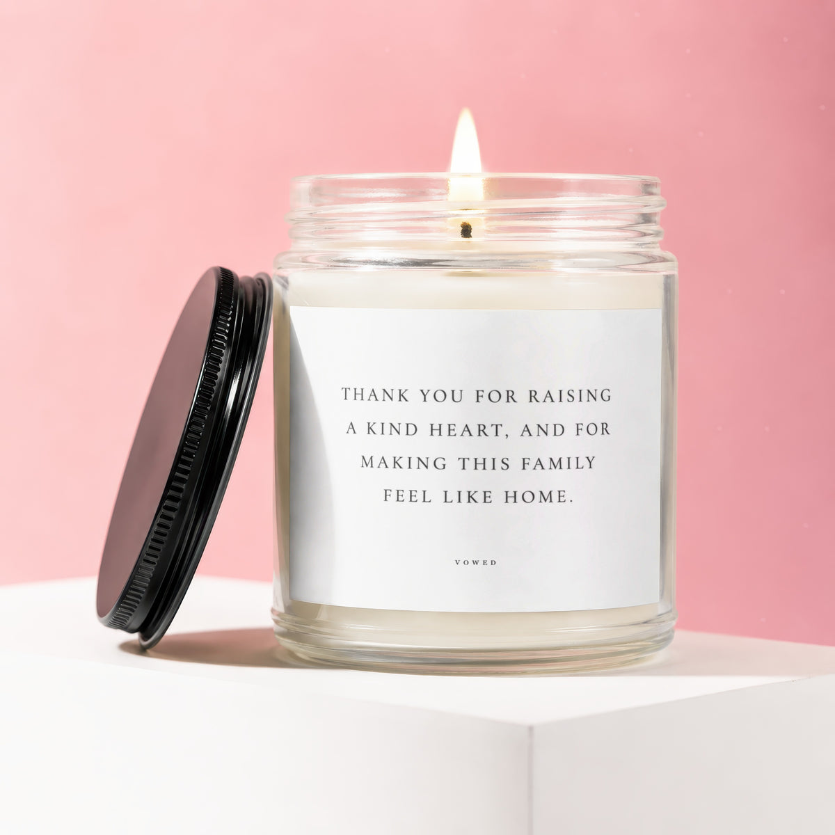 Jar candle with lit wick and black lid, reading "Thank You For Raising A Kind Heart"